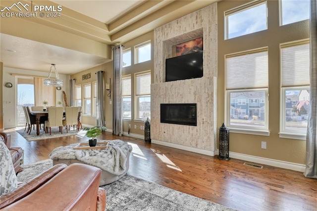 living room featuring hardwood / wood-style floors, a fireplace, and a chandelier