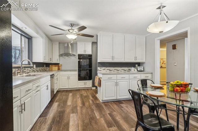 kitchen with sink, white cabinetry, double oven, dark hardwood / wood-style floors, and wall chimney exhaust hood