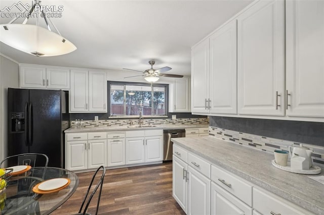 kitchen featuring sink, dishwasher, white cabinets, black fridge, and decorative light fixtures