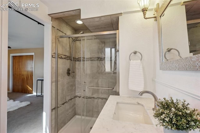 bathroom featuring an enclosed shower and vanity