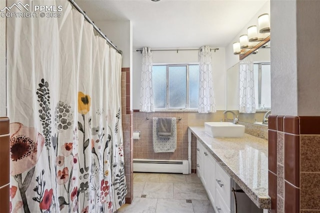 bathroom featuring vanity, curtained shower, tile walls, and a baseboard heating unit