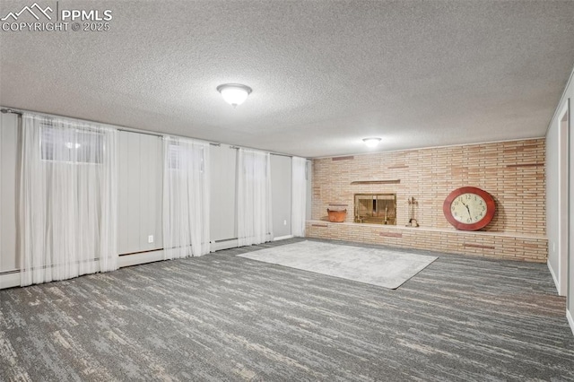 basement with a textured ceiling, a fireplace, brick wall, and dark colored carpet