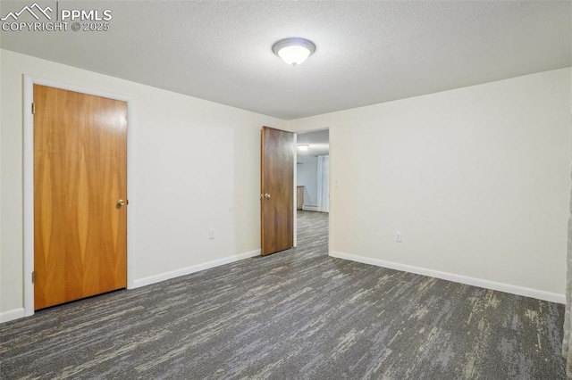 unfurnished room with dark wood-type flooring and a textured ceiling