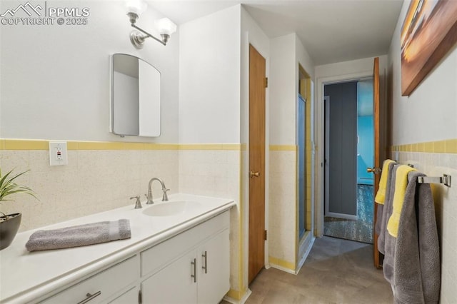 bathroom with vanity and tile walls