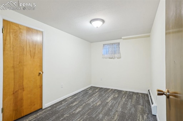 unfurnished room with a baseboard radiator, dark hardwood / wood-style floors, and a textured ceiling