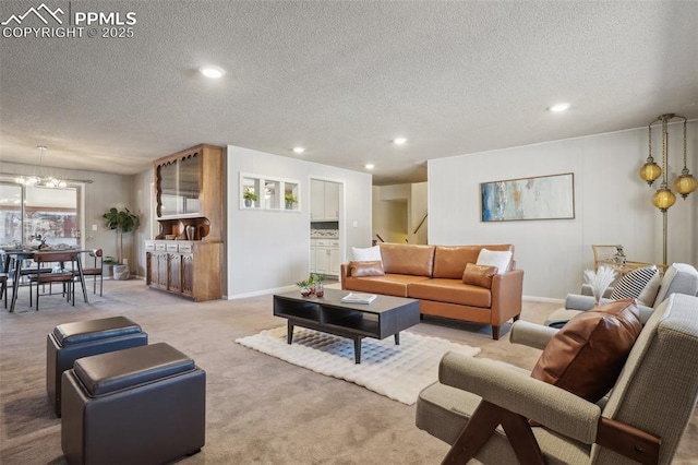 carpeted living room with a chandelier and a textured ceiling