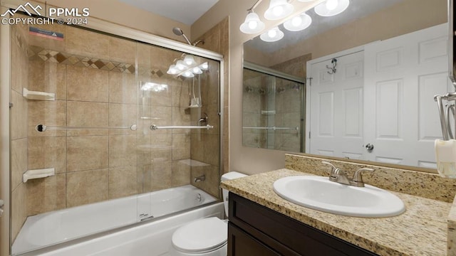 full bathroom featuring vanity, toilet, and bath / shower combo with glass door