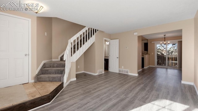 entryway with a chandelier and wood-type flooring