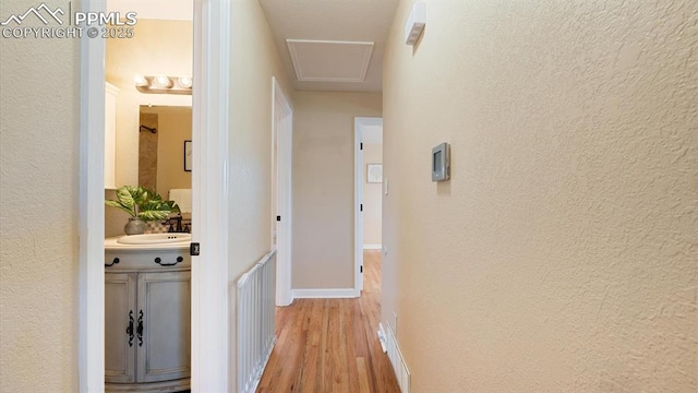 corridor with sink and light hardwood / wood-style floors