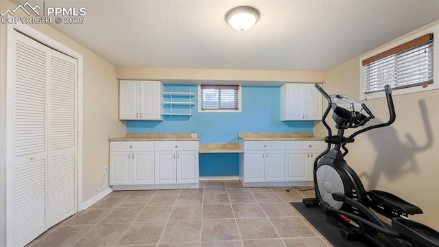 workout room with light tile patterned floors and a wealth of natural light