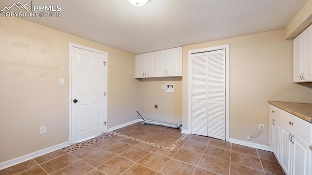 laundry area featuring washer hookup, cabinets, electric dryer hookup, and a textured ceiling