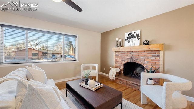 living room featuring a fireplace, ceiling fan, and wood-type flooring