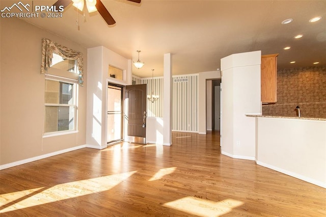 unfurnished living room with ceiling fan, sink, and light hardwood / wood-style flooring