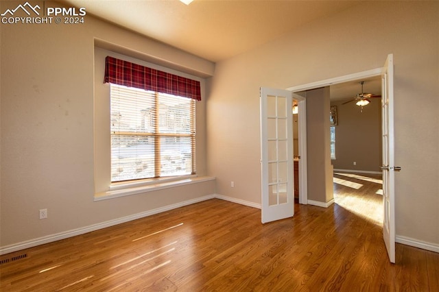 spare room with ceiling fan, french doors, and hardwood / wood-style floors