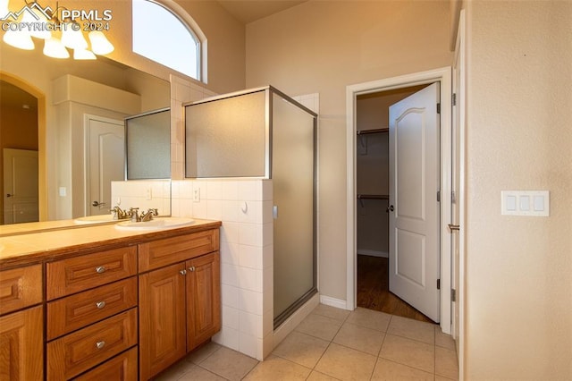 bathroom featuring tile patterned flooring, vanity, and an enclosed shower