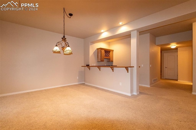 unfurnished room featuring light colored carpet and an inviting chandelier