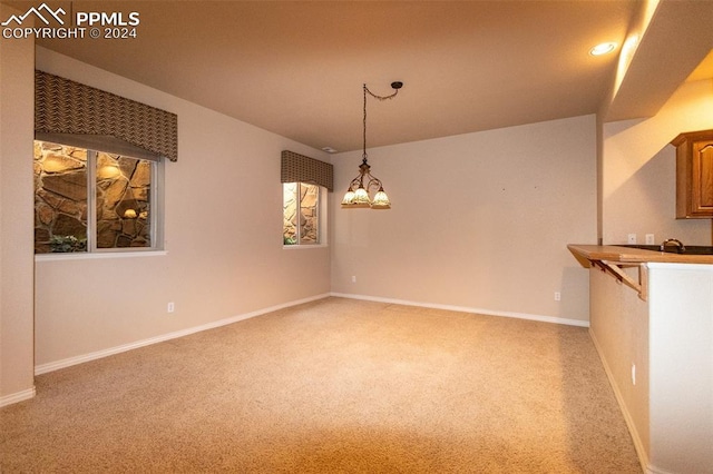 unfurnished room featuring carpet floors and an inviting chandelier