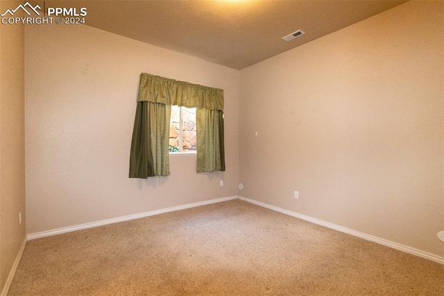 empty room with carpet floors and lofted ceiling