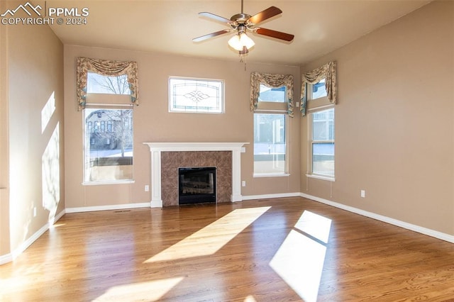 unfurnished living room with hardwood / wood-style flooring, plenty of natural light, and ceiling fan