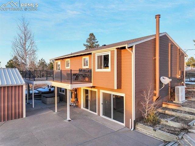 back of property with a jacuzzi, ac unit, a patio, and a storage unit