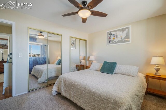 bedroom with carpet flooring, ceiling fan, and multiple closets