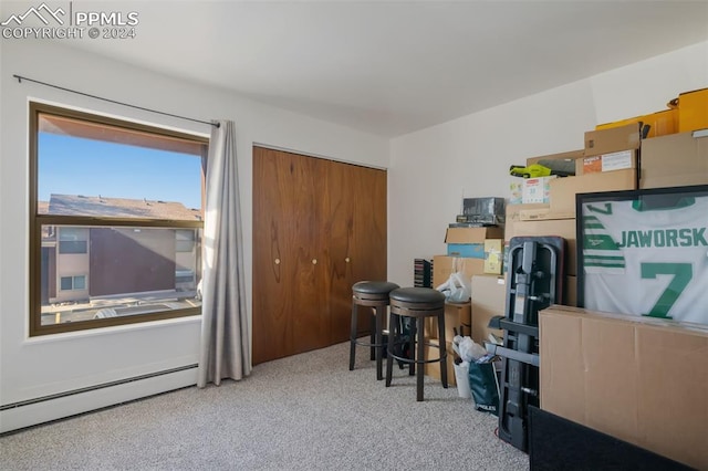 office space with a baseboard heating unit and light carpet