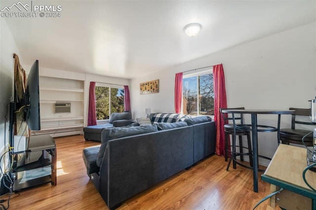 living room with a wall unit AC and hardwood / wood-style flooring