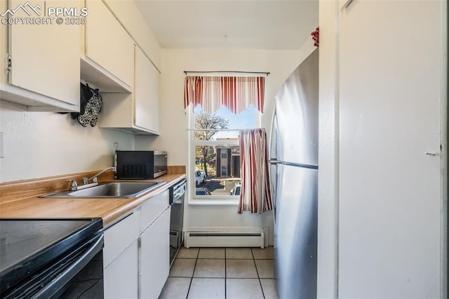 kitchen with stainless steel refrigerator, a baseboard heating unit, sink, white cabinets, and light tile patterned flooring