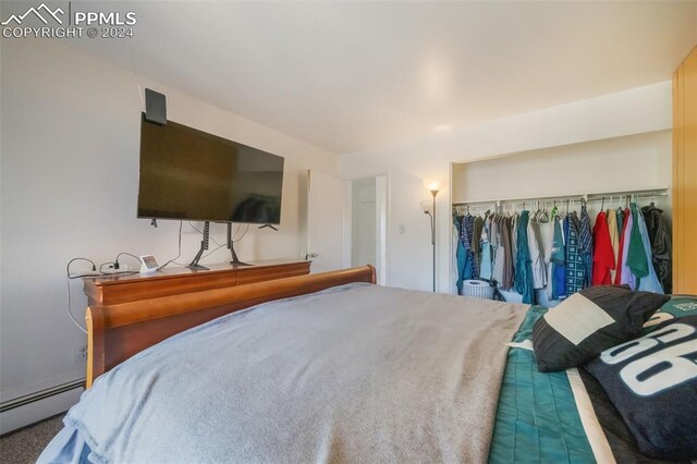 bedroom featuring a baseboard radiator and a closet