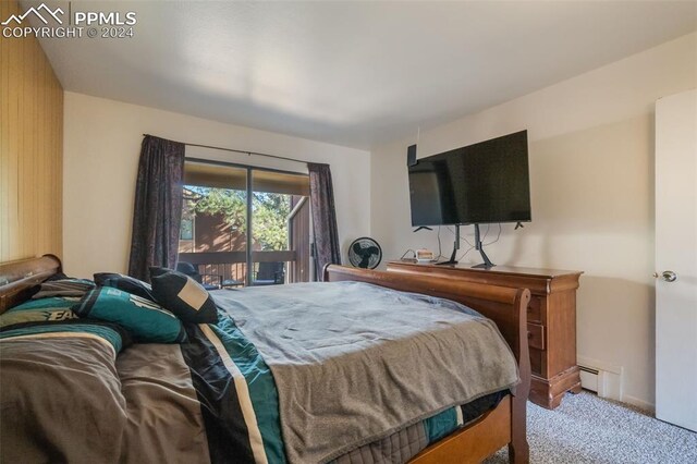 carpeted bedroom featuring a baseboard heating unit