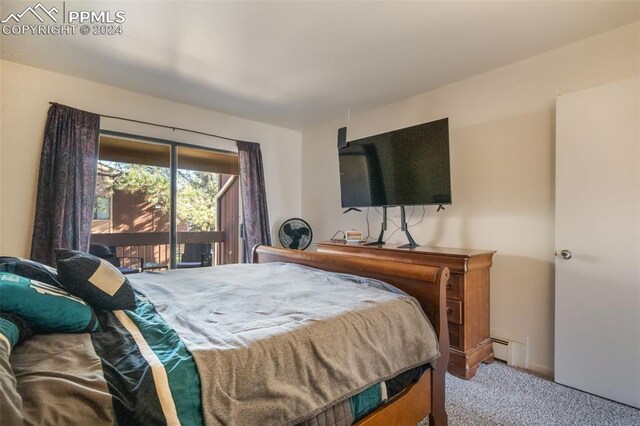 bedroom with access to outside, carpet floors, and a baseboard heating unit