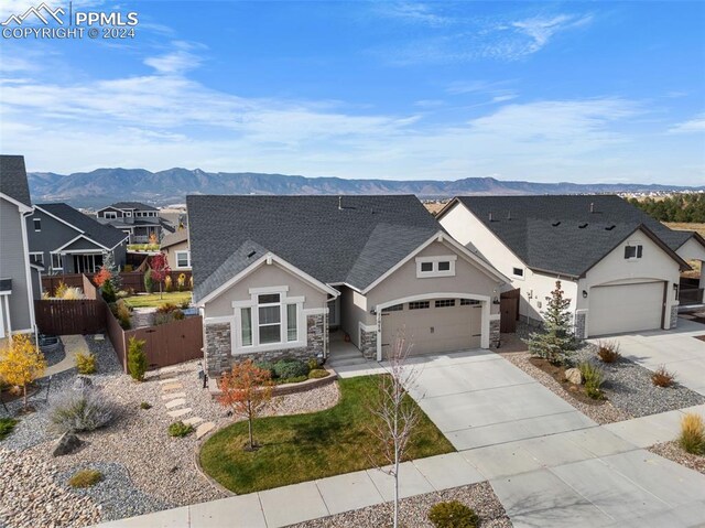 view of front facade with a mountain view, a garage, and a front lawn