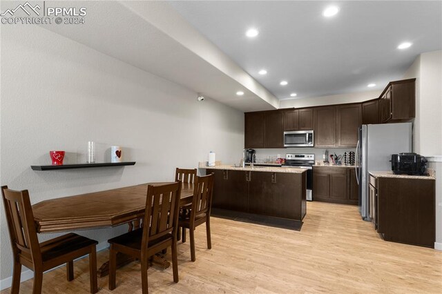 kitchen with sink, light wood-type flooring, stainless steel appliances, and dark brown cabinetry