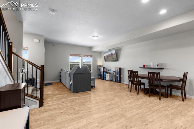 living room featuring a textured ceiling and light wood-type flooring