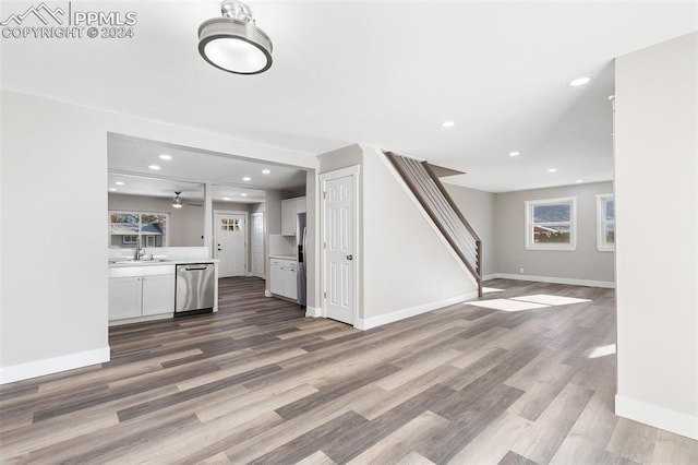 kitchen featuring white cabinetry, wood-type flooring, sink, and appliances with stainless steel finishes