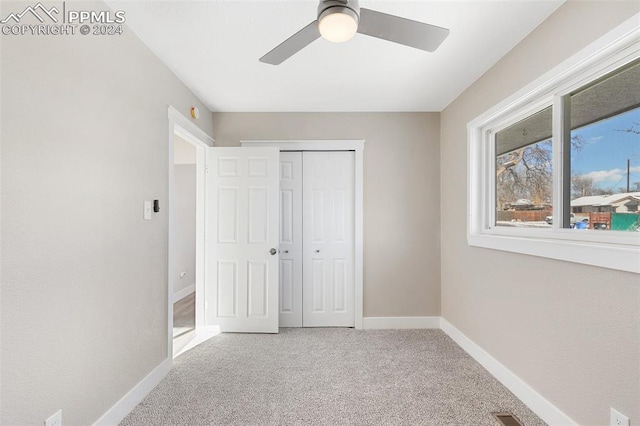 unfurnished bedroom with carpet flooring, ceiling fan, and a closet