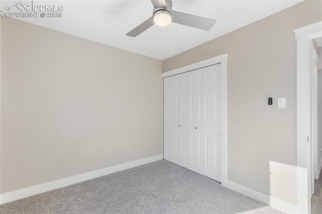 unfurnished bedroom with a closet, ceiling fan, and light colored carpet