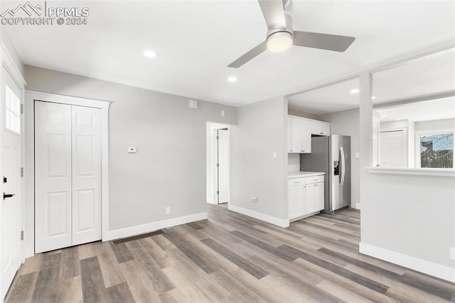 unfurnished living room with light wood-type flooring, ceiling fan, and a healthy amount of sunlight