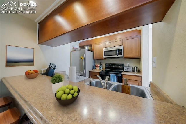 kitchen with kitchen peninsula, stainless steel appliances, a breakfast bar area, and sink