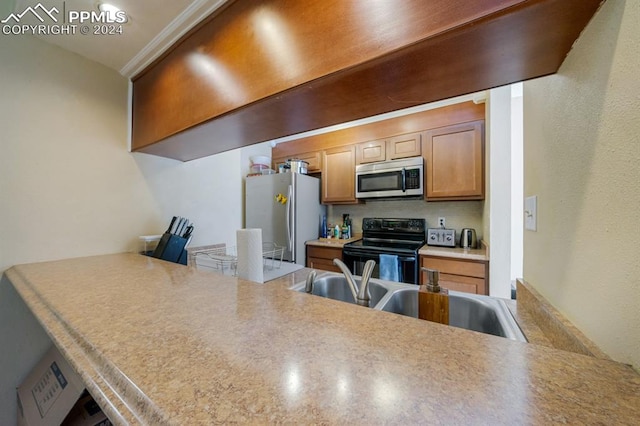 kitchen featuring kitchen peninsula, sink, and appliances with stainless steel finishes