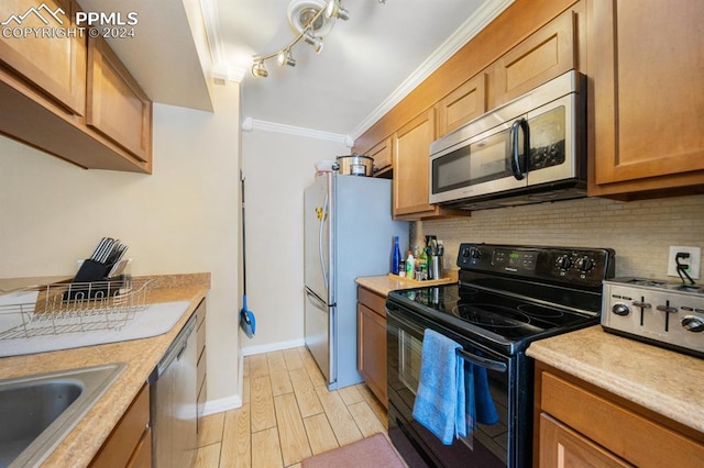 kitchen featuring sink, crown molding, light hardwood / wood-style flooring, decorative backsplash, and appliances with stainless steel finishes