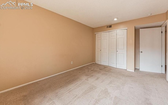 unfurnished bedroom with carpet flooring and a closet