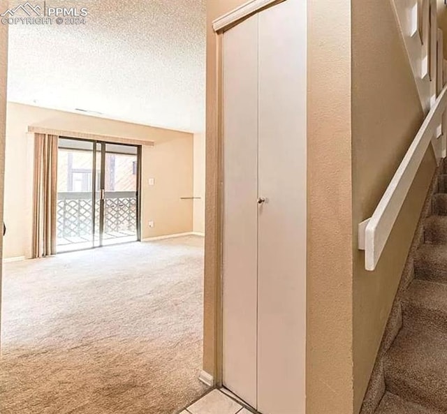 hall featuring french doors, carpet, and a textured ceiling