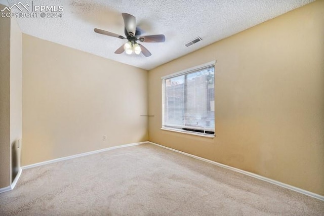 carpeted spare room with a textured ceiling and ceiling fan