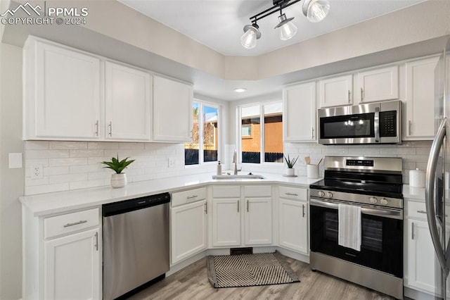 kitchen featuring light hardwood / wood-style floors, white cabinetry, sink, and appliances with stainless steel finishes