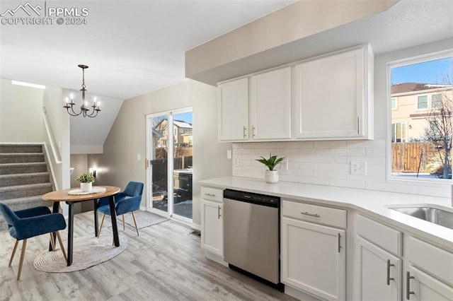 kitchen featuring dishwasher, lofted ceiling, white cabinets, hanging light fixtures, and light wood-type flooring