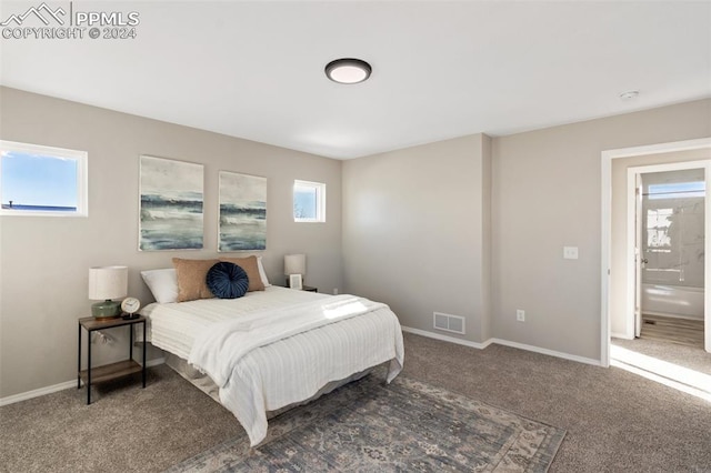 carpeted bedroom featuring ensuite bath