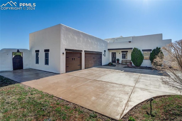 pueblo revival-style home featuring a garage