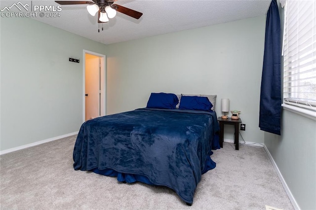 bedroom with carpet, a textured ceiling, and ceiling fan