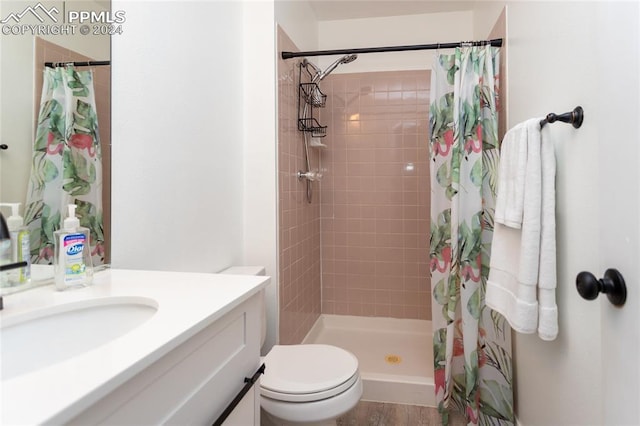 bathroom featuring a shower with curtain, vanity, hardwood / wood-style flooring, and toilet